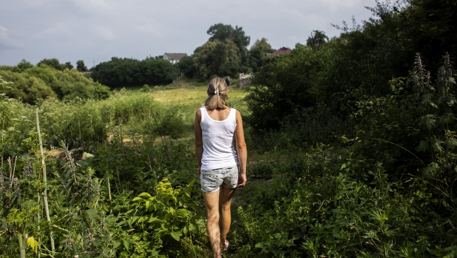A woman walking towards a lake